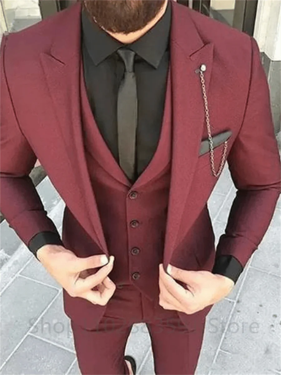 Men's burgundy slim fit suit by Showlu Fashion, featuring a wool peak lapel tuxedo jacket, vest, and matching pants for formal occasions.