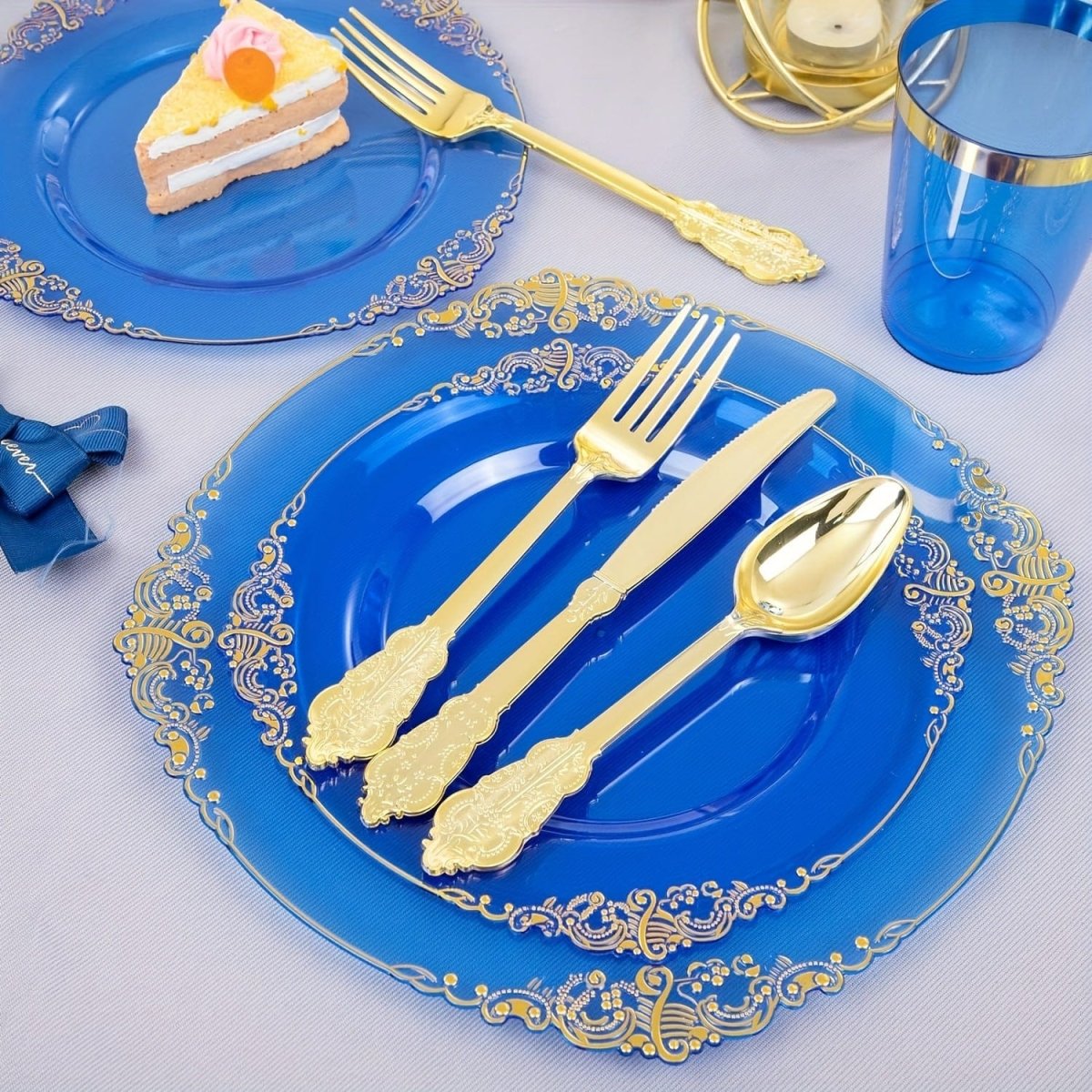 Blue plastic dinnerware set with 50 plates, cups, napkins, and gold silverware for 50 guests, perfect for parties and weddings.