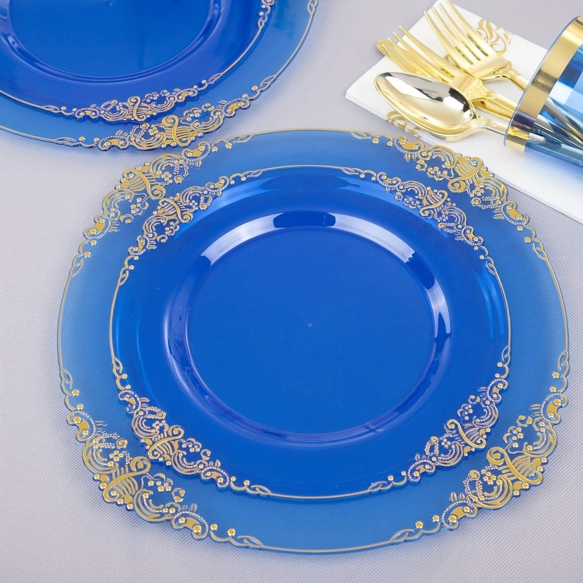 Blue plastic dinnerware set including 50 plates, cups, napkins, and gold silverware for 50 guests at parties and events.
