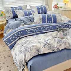A four-piece cotton bedding set featuring a blue and white floral pattern with Monte Carlo text.