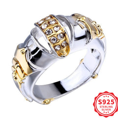 A silver and gold-toned ring featuring a stylized fish mouth design accented with small stones.