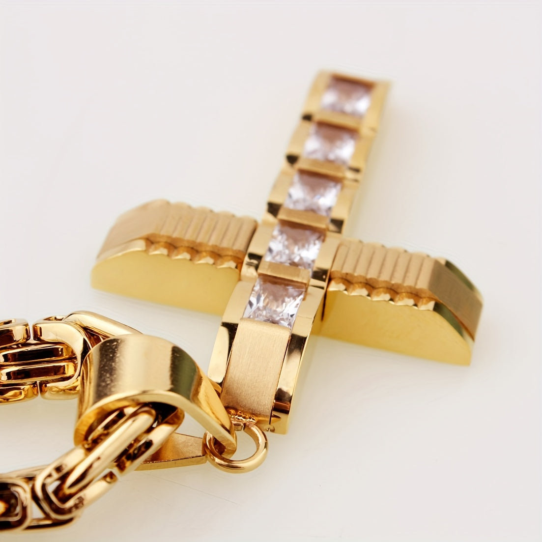 Showlu men's 14K gold plated stainless steel cross pendant necklace hanging on a chain, close-up view of the jewelry piece.
