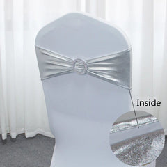 A metallic silver spandex chair sash featuring a decorative circular buckle at the center.