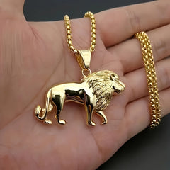 A gold-plated stainless steel lion pendant necklace held in a hand.