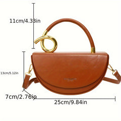 A brown saddle-style crossbody bag with a gold circular handle and shoulder strap.
