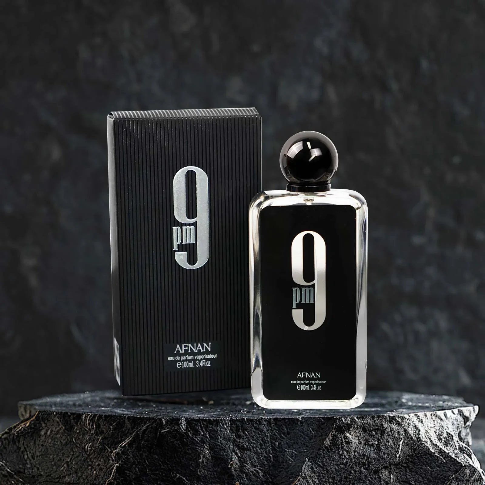 A bottle of Afnan 9PM Men's Eau De Parfum with a spicy scent in a 3.4 oz bottle, shown with the perfume spray and packaging.