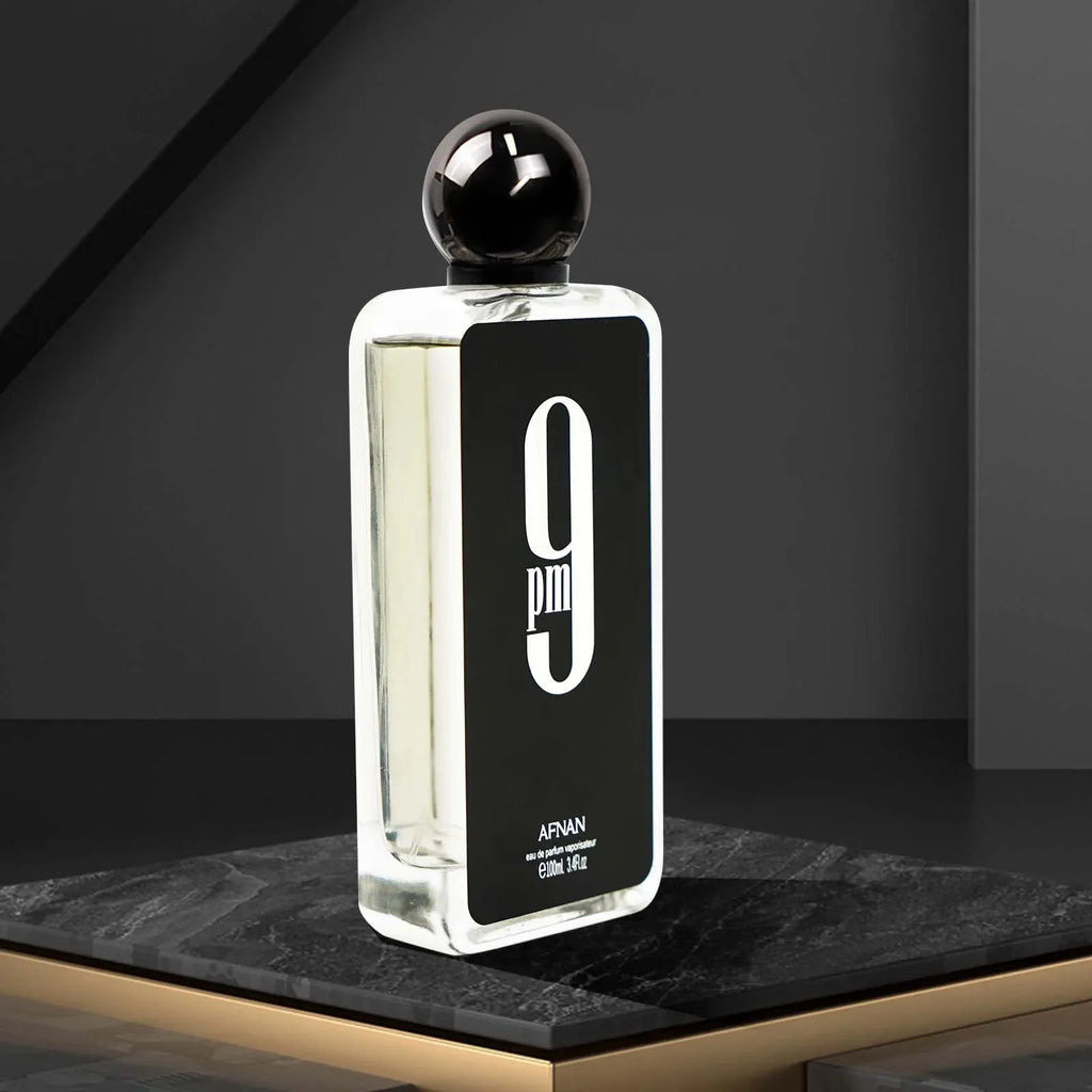A 3.4 oz bottle of Afnan 9PM men's Eau De Parfum with a long-lasting spicy scent, displayed with the perfume spray and packaging.