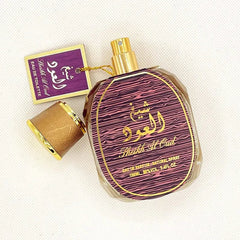 A bottle of Sheikh Al Oud perfume with a gold cap and a purple label on a white background.