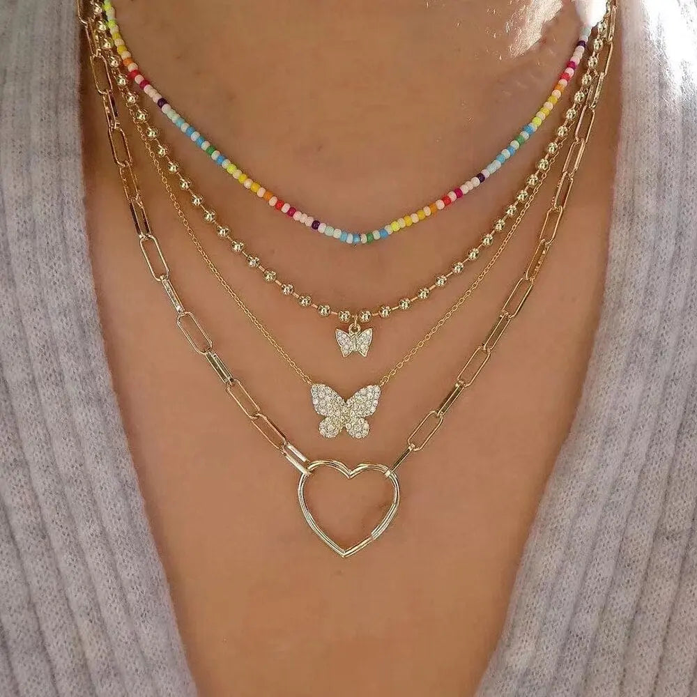 Gold boho multilayer chain necklace with pearl, cross, and heart pendants, stylish and elegant jewelry for women.