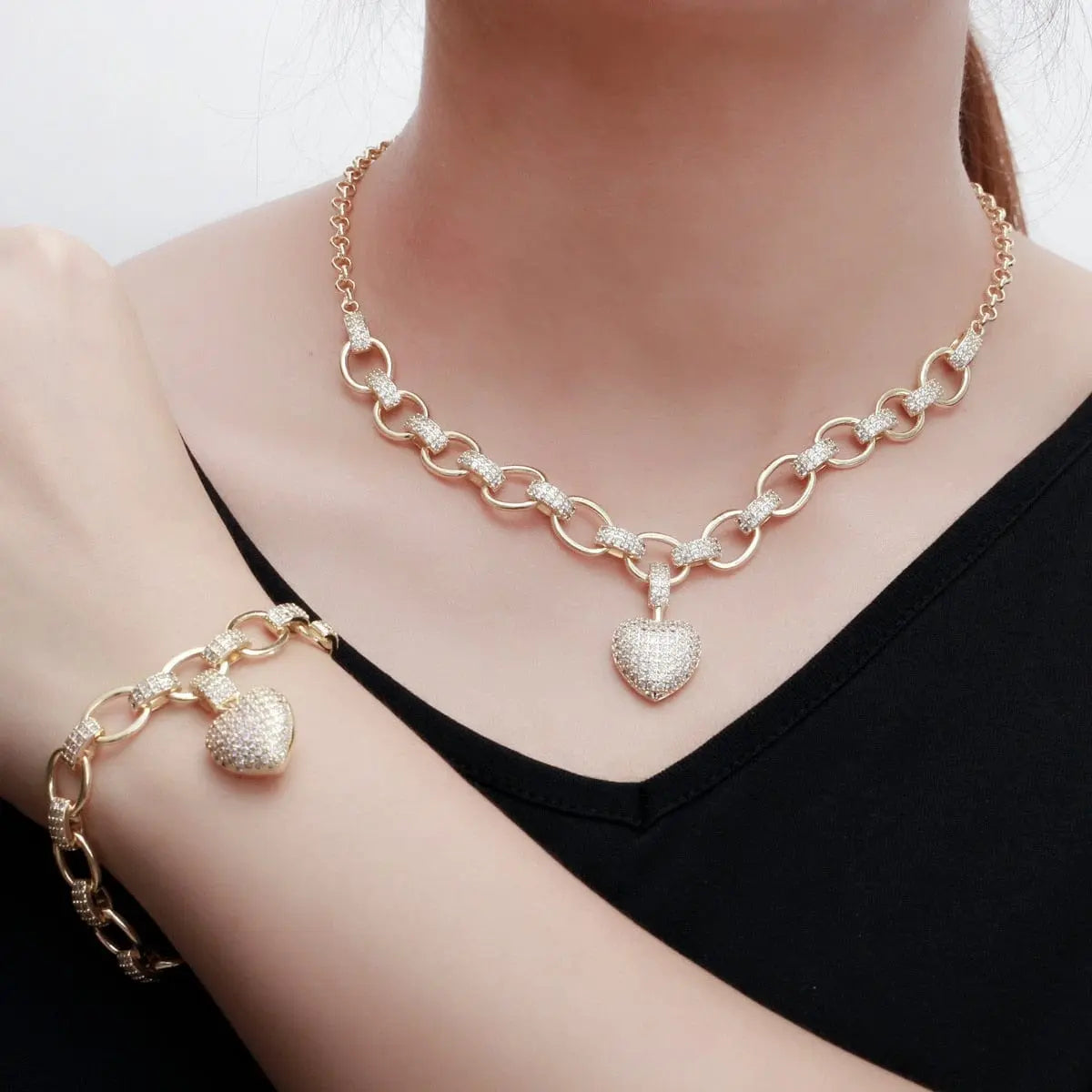 Gold heart pendant necklace and bracelet jewelry set with cubic zirconia, featuring love heart charms for women.