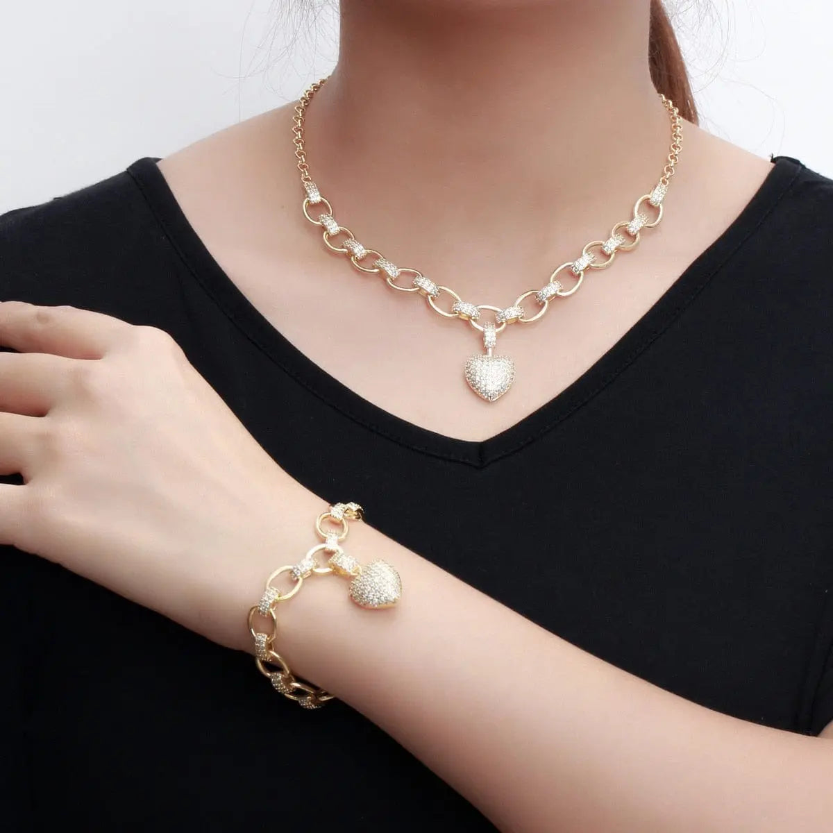 Gold heart pendant necklace and bracelet jewelry set with cubic zirconia dangles, perfect for women’s costume jewelry.
