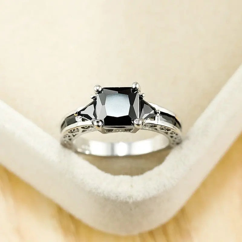 Elegant women's silver wedding ring with princess cut black zircon stones, showcasing a delicate and trendy design.
