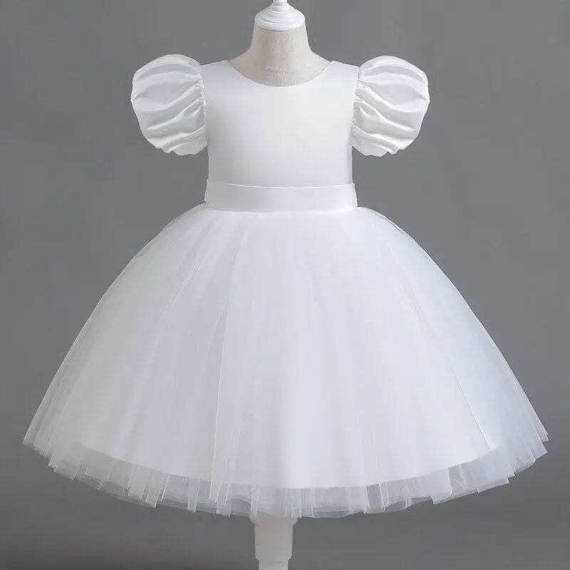 White tulle flower girl dress by Showlu Fashion Store, elegant fluffy gown for kids' weddings, birthdays, and special occasions.