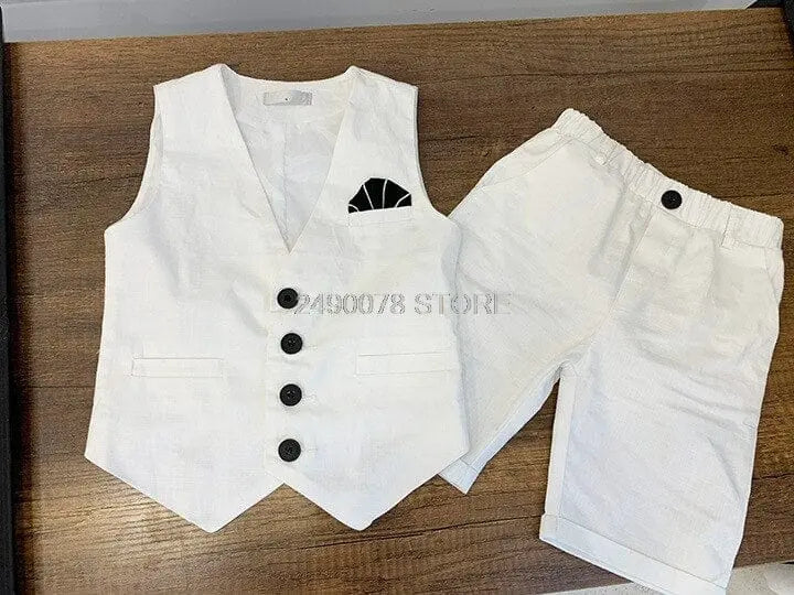 Boy wearing a white wedding suit with a bowtie, formal tuxedo style, suitable for ceremonies or parties, by Showlu Fashion Store.