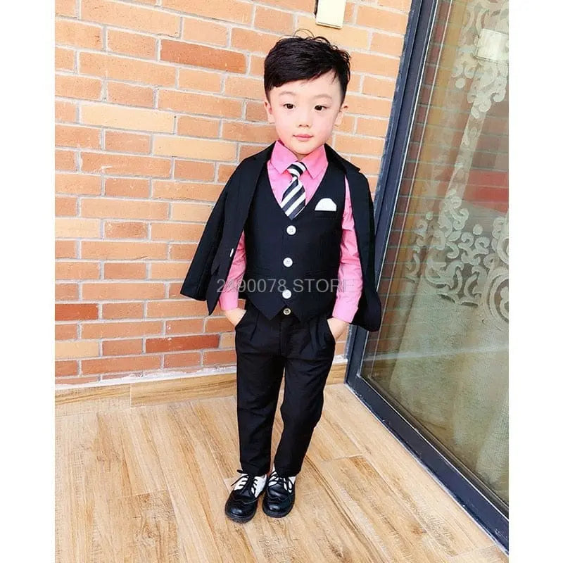 Young boy in a white wedding suit with a bowtie, formal tuxedo style, perfect for special occasions and ceremonies.