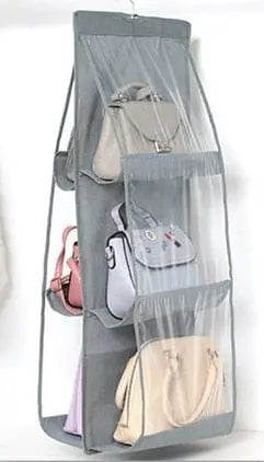 Transparent hanging handbag organizer from Anel Demosthene General Store, with multiple compartments for closet storage.