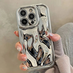 A hand holds a silver phone case with a glossy, liquid-like metallic texture.