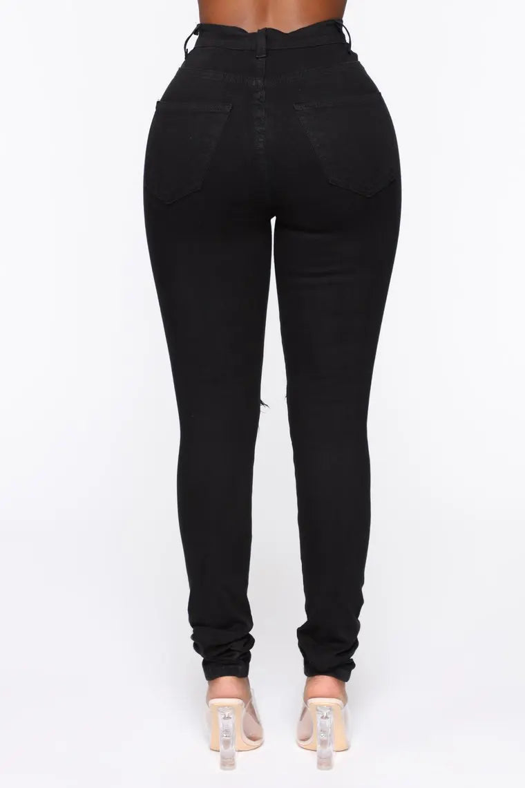 Black and white ripped skinny jeans for women, casual streetwear denim pants with stretch, shown in a fitted style from Showlu Fashion.