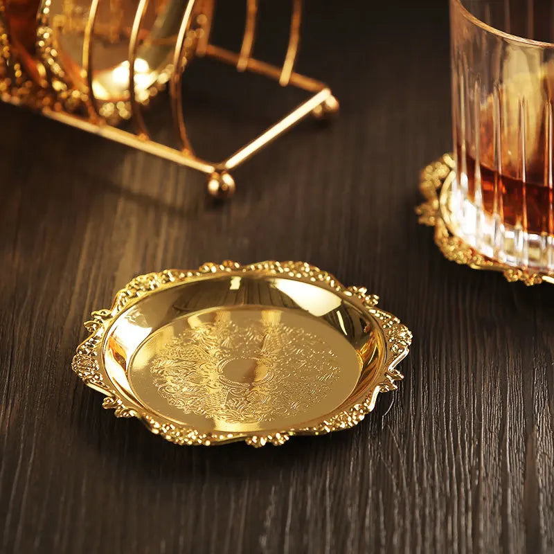 Six vintage golden metal cocktail coasters with zinc alloy and silver-plated finishes, set on a classic placemat.