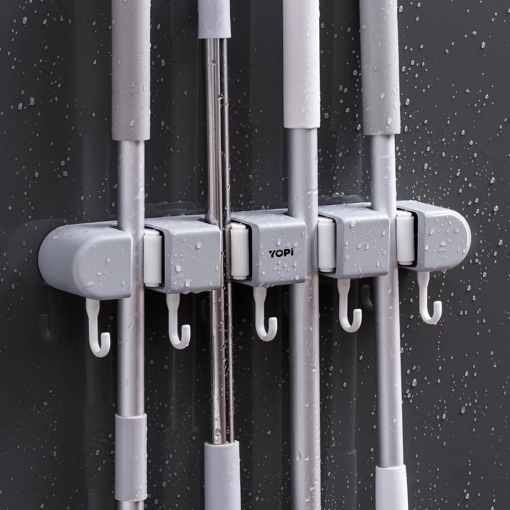 Wall mounted broom holder by Showlu Smart General, showing a sturdy plastic rack with multiple slots for organizing brooms and cleaning tools.