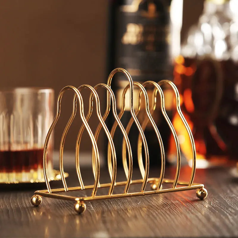 Six vintage gold and silver plated metal cocktail coasters with classical design, perfect for elegant table settings.