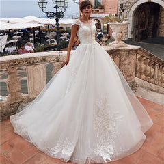 A sleeveless white ball gown wedding dress with lace appliques and a corset bodice.