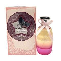 A bottle of Hareem Al Sultan perfume with a pink bow next to its matching decorative box.
