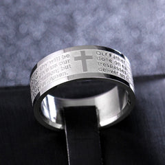 A silver-toned stainless steel ring engraved with the Lord's Prayer and a central cross.