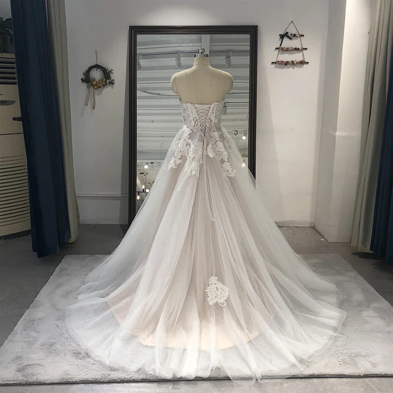Strapless tulle bridal gown with lace appliqué, A-line silhouette, sweetheart neckline, court train, perfect for wedding dresses.
