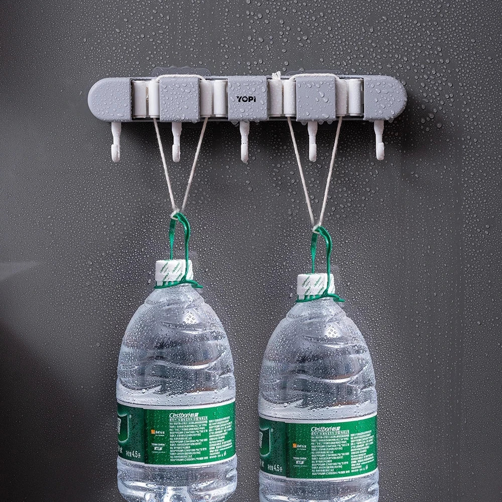 Wall mounted broom holder by Showlu Smart General holding brooms and cleaning tools against a wall.