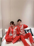 Couple wearing Showlu Fashion silk satin Korean style pajamas set, featuring matching nightwear for men and women.