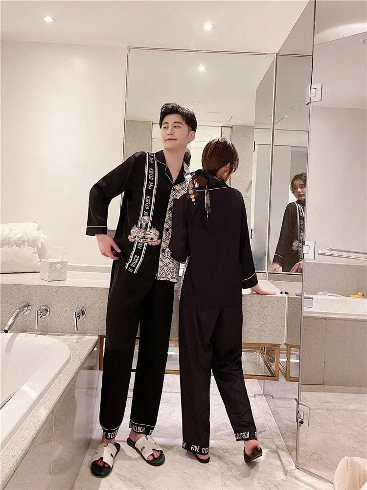 Couple wearing Showlu Fashion silk satin Korean-style pajamas set, stylish nightwear with matching men's and women's sleepwear.