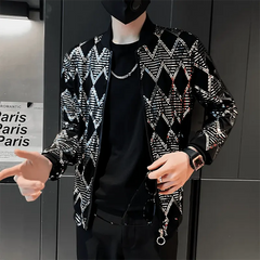 A man wears a black bomber jacket featuring a silver diamond pattern and a front zipper closure.