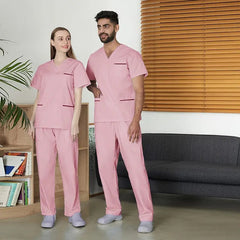 A man and a woman wearing matching pink scrub sets with pockets in a professional setting.