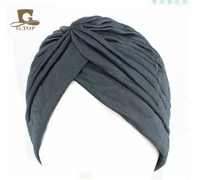 Stretchy women's turban cap with twisted pleats in assorted colors, designed as a chemo beanie hat for women and girls.