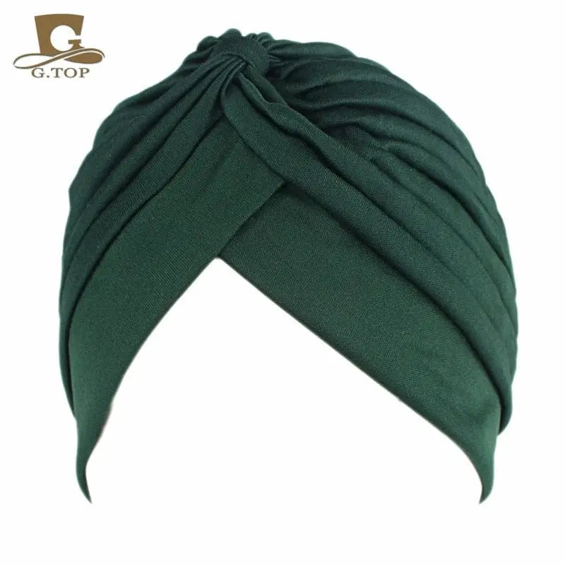 Stretchy women's twisted pleated turban cap in assorted colors, designed as a chemo head covering and stylish beanie hat.