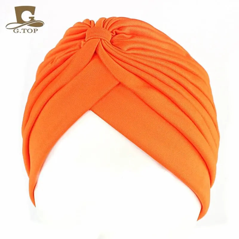 Stretchy women's turban cap with twisted pleats, chemo beanie hat in assorted colors, designed for comfortable head coverage.
