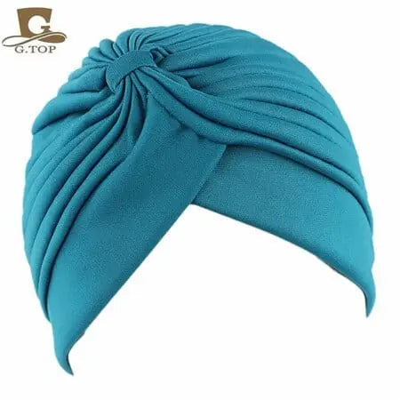 Stretchy women’s turban cap with twisted pleated design, in assorted colors, provides comfortable head coverage and hair support.