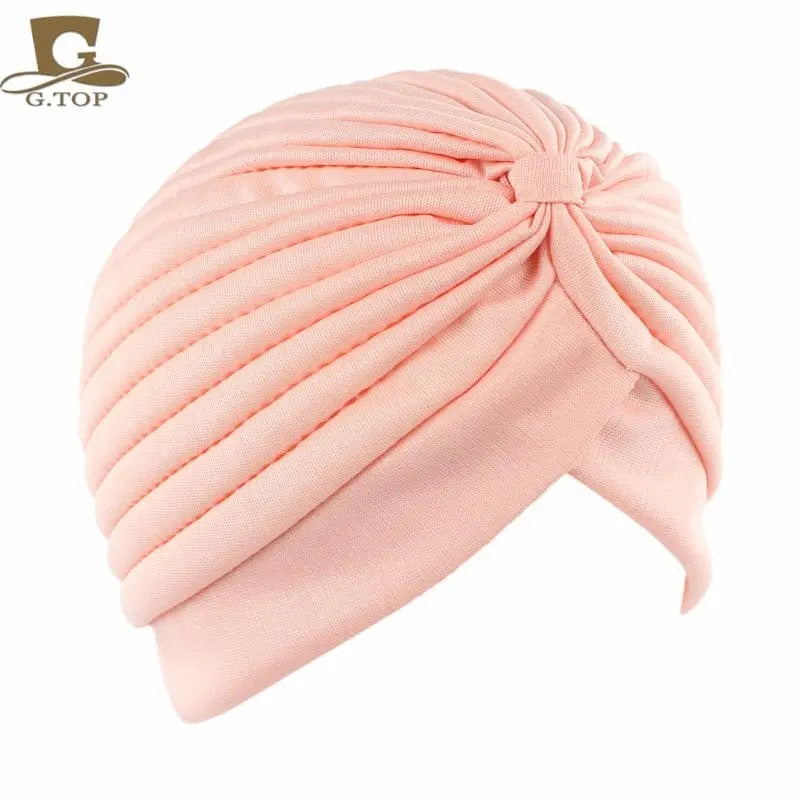 Stretchy women's turban cap with twisted pleated design, in assorted colors, ideal as a chemo head covering or stylish hair wrap