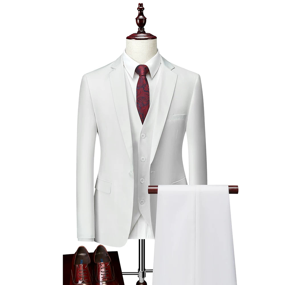 A white slim-fit three-piece suit with a red patterned tie and brown dress shoes.