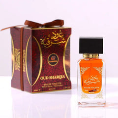A bottle of Oud Sharqia eau de toilette perfume stands next to its matching decorative box.