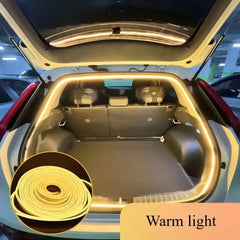 A warm-toned LED light strip installed around the interior edge of an open car trunk.
