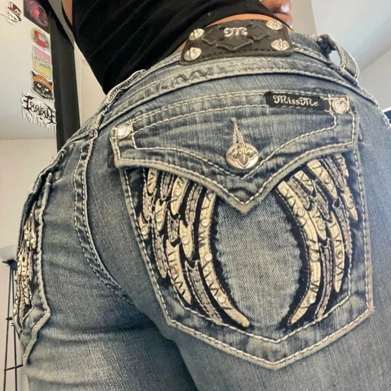 Blue low-rise flared denim jeans for women with rhinestone wing embroidery and studded pockets, by American Vintage Y2K streetwear style