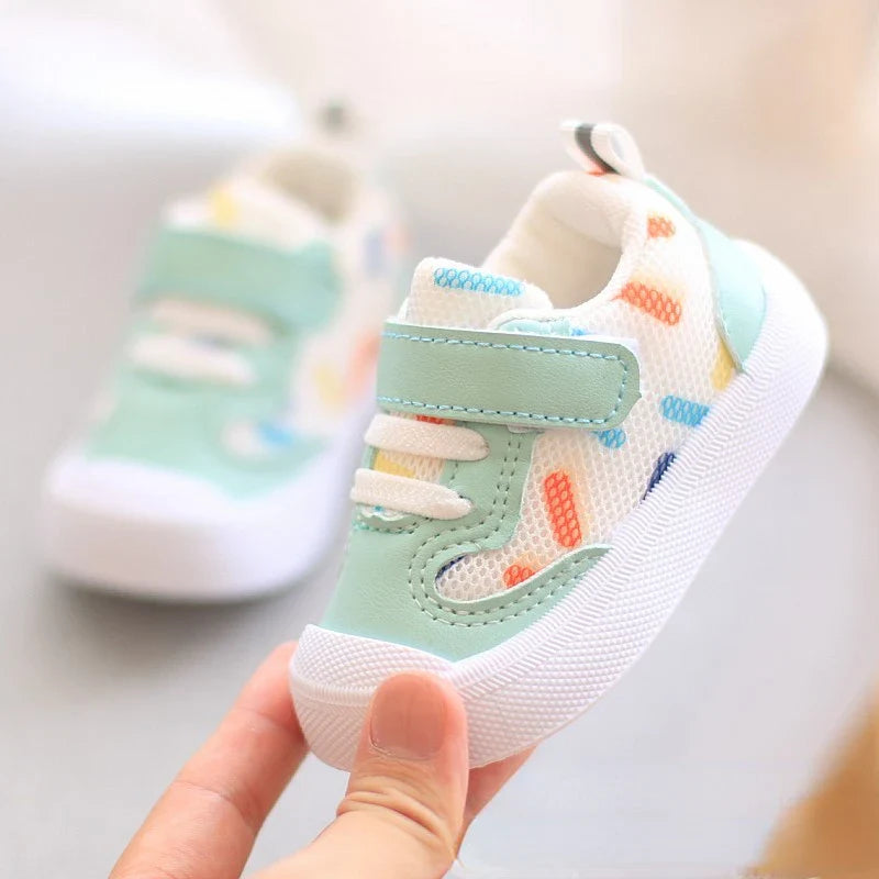 Unisex baby sports shoes with mesh upper and soft sole, showing lightweight, comfortable design for little feet.