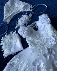 A white baby girl baptism gown with lace, pearls, and 3D flowers, including a matching bonnet.