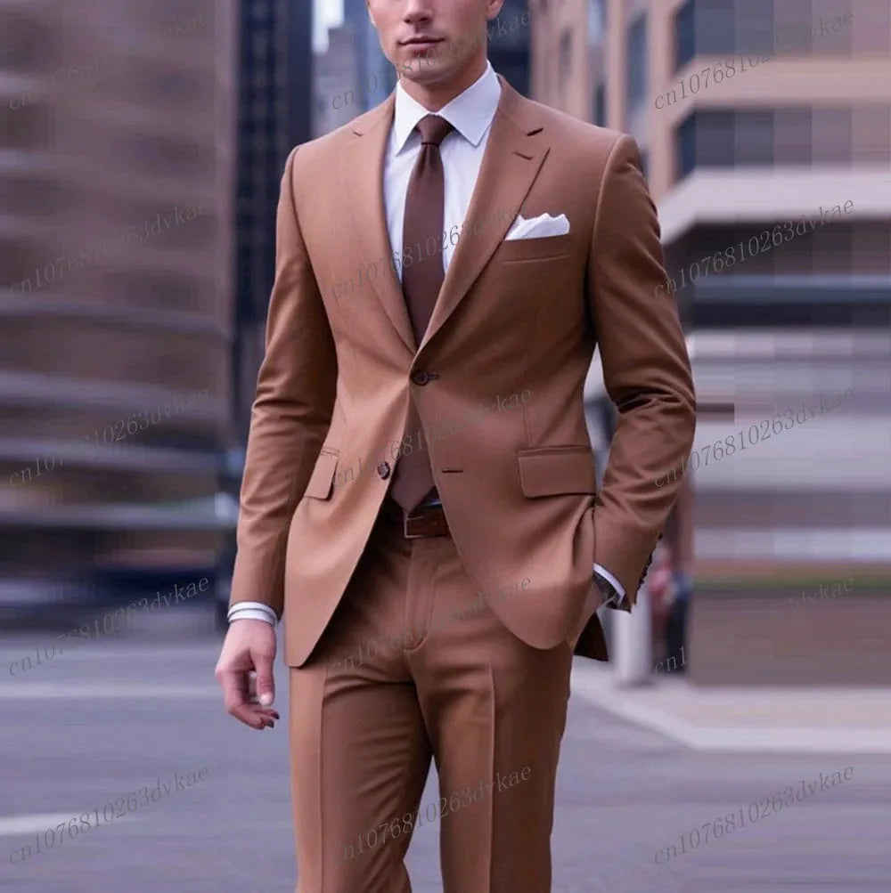 A man wears a formal brown two-piece suit with a white shirt and brown tie.
