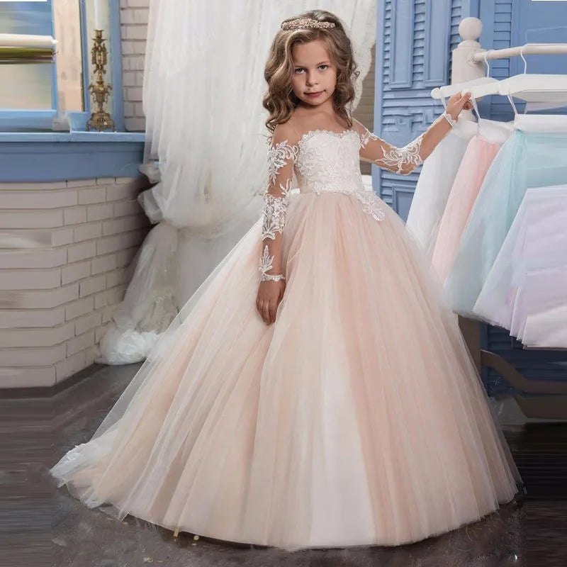 Light pink flower girl dress with white appliques, tulle skirt, and long sleeves for wedding and special occasions.