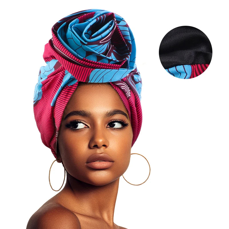 Woman wearing Showlu Fashion African satin-lined turban cap with floral print and large flower embellishment, stylish headwrap bonnet.
