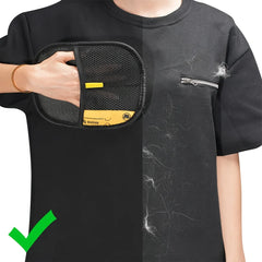 A person uses a black mesh grooming glove to remove pet hair from a black t-shirt.