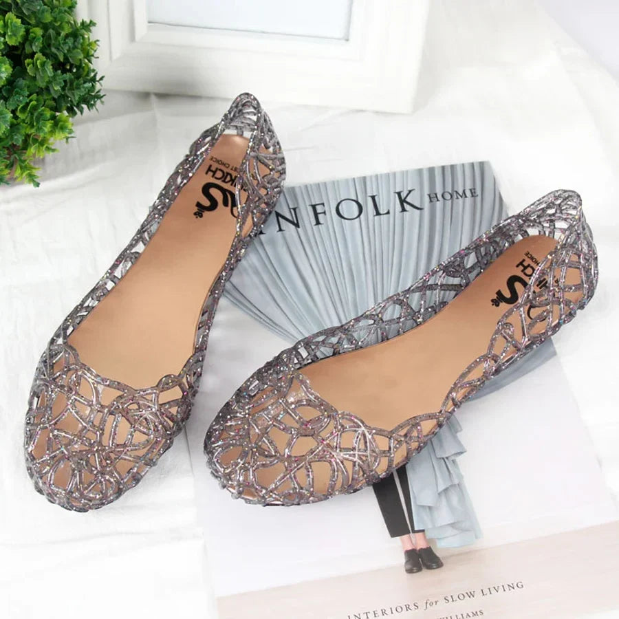 Showlu Fashion women's crystal jelly flat Roman beach sandals with clear straps and decorative embellishments.